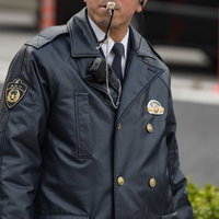 笛を吹いて警備にあたる警察官の写真