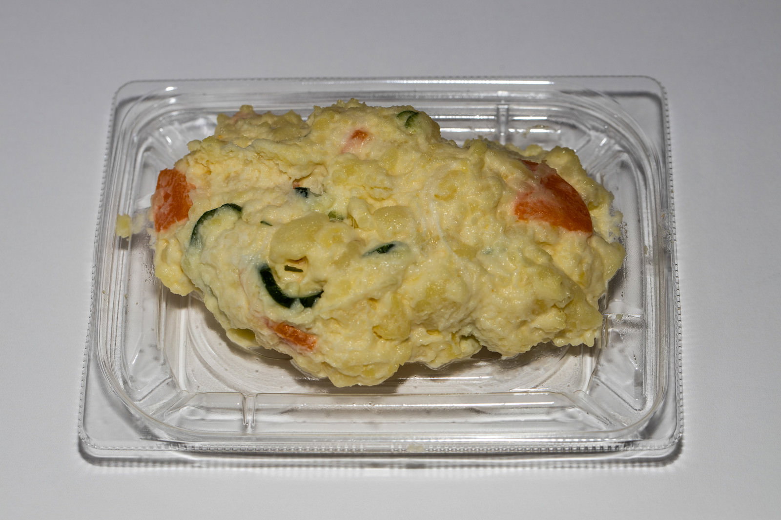透明なプラスチック容器に入った黄色いポテトサラダ
