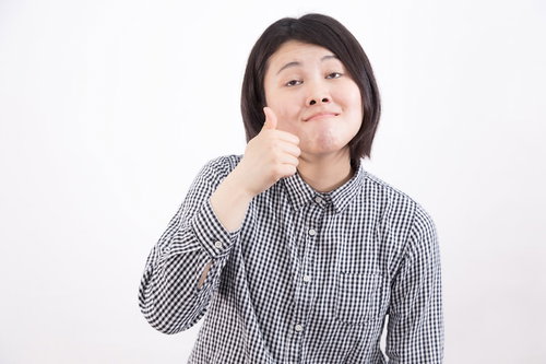 接待で考える仕草をする女性のいいね、サムズアップ