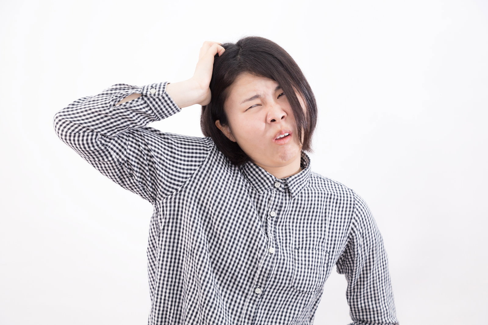 顎に手を当てて悩む若い女性［モデル：佐竹PP］