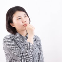 上を見上げて妄想にふける女性のビジネスポーズの写真