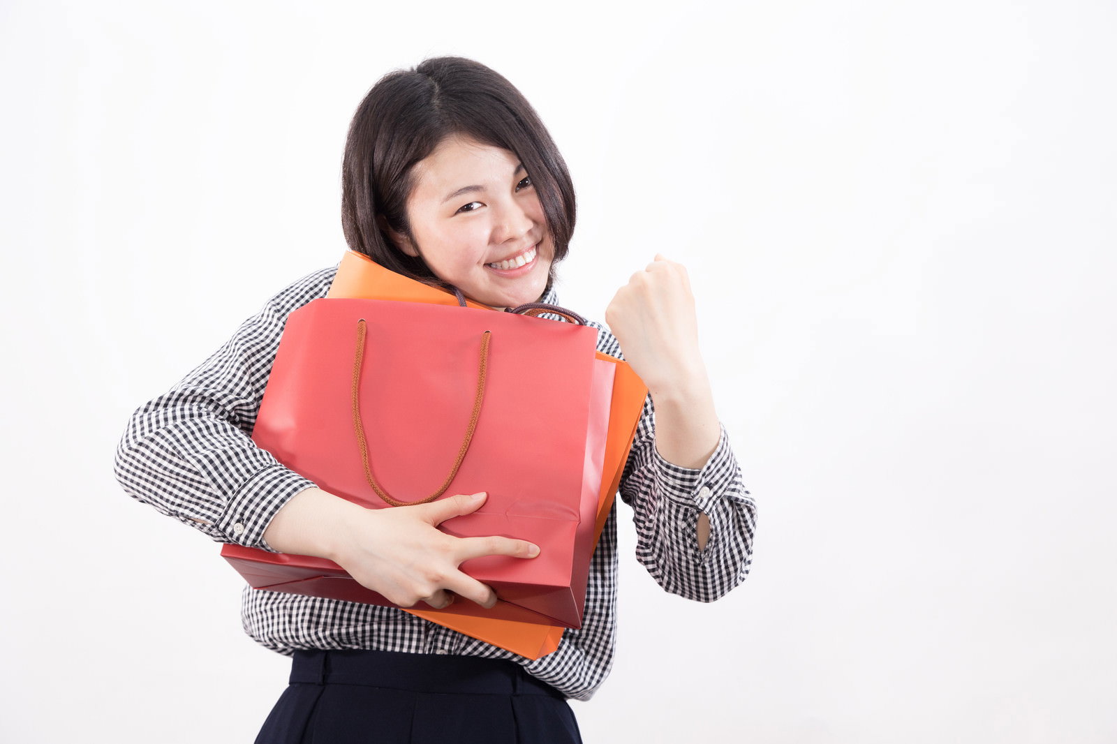 赤い福袋を抱えてガッツポーズを決める女性［モデル：佐竹PP］