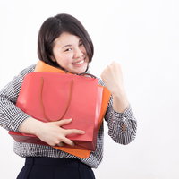 お客様お一人様一点までです 福袋を抱えてガッツポーズする女性の写真