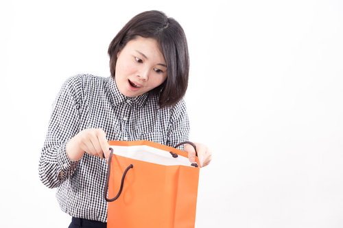 セール品のお楽しみ袋を開封する女性