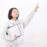 指をさしてナンバーワンの目標を掲げる女性作業員の写真