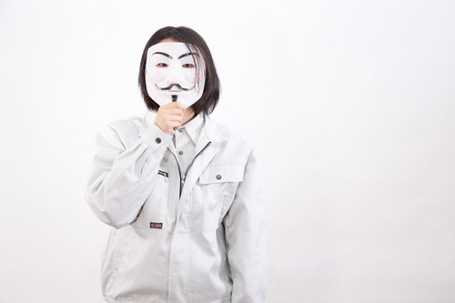 アノニマスマスクをつけた内部告発する従業員