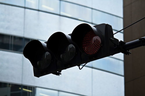 ビルの前で点灯するLEDの赤信号