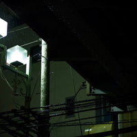 夜の高架下に点灯する六角形の街灯の写真