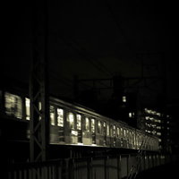 夜間に高架を通過中の電車の写真