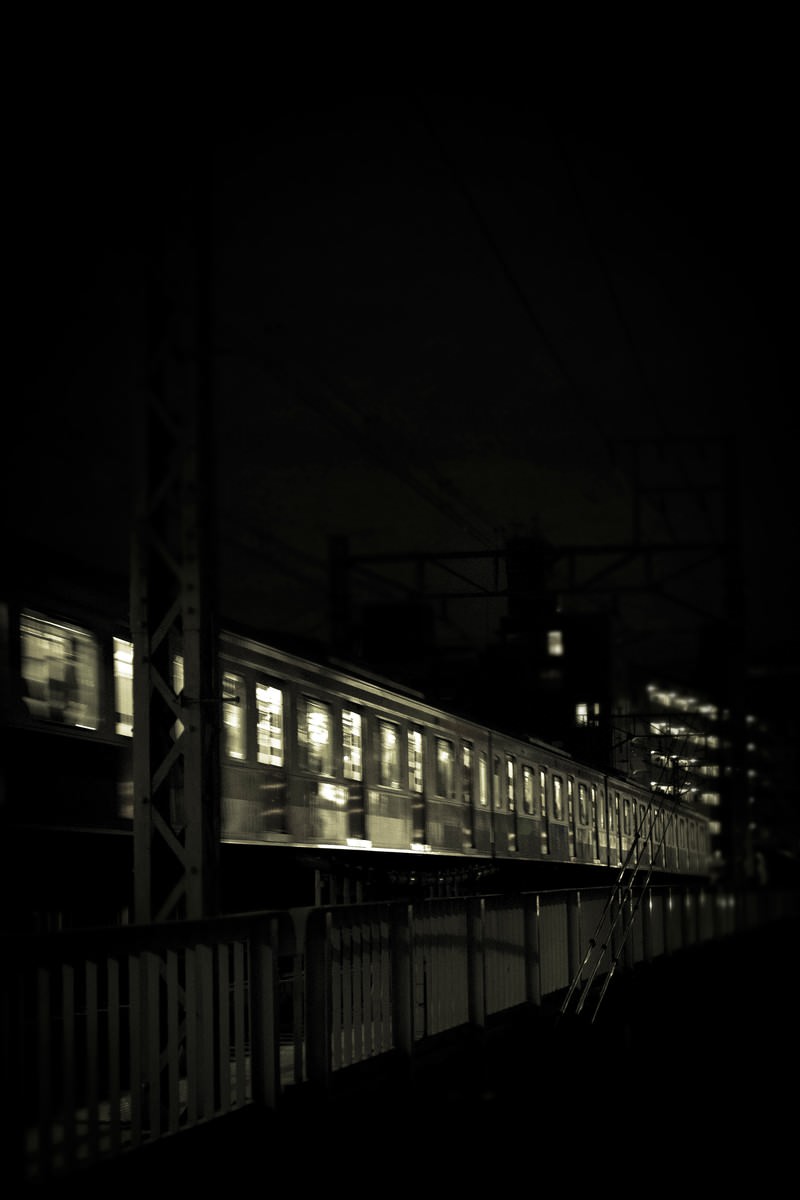 夜間に高架を走行する電車