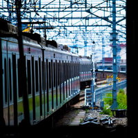 駅のホームですれ違う白い電車の写真