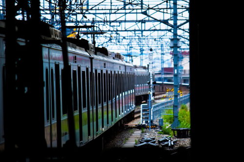 駅のホームですれ違う白い電車