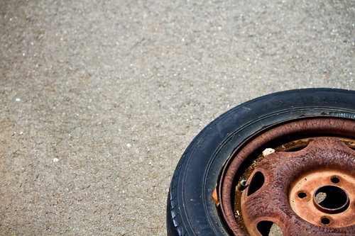コンクリートの上に放置された錆びたタイヤ