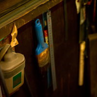 木製の壁に掛けられたスケール等の工具類の写真