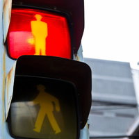 赤と黄色に光る歩行者用信号機の街角の写真