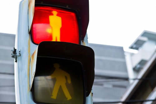 赤と黄色に光る歩行者用信号機の街角