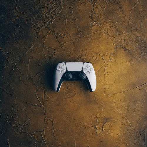 白いプレステ5のコントローラーを茶色い背景に置いた