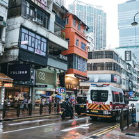 香港の市街地を走る警察車両と周囲の建物の夜間風景の写真