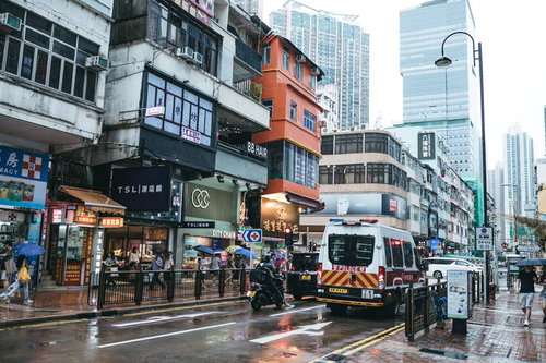 香港の市街地を走る警察車両と周囲の建物の夜間風景