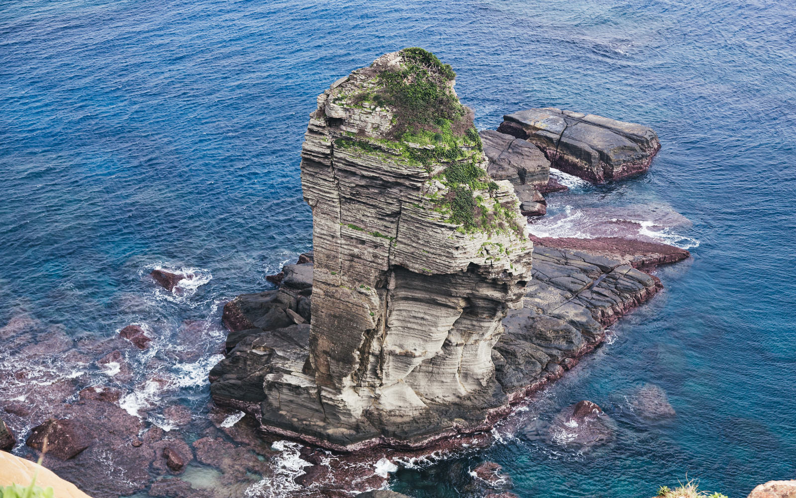 青い海に囲まれた与那国島の立神岩を上空から撮影した風景