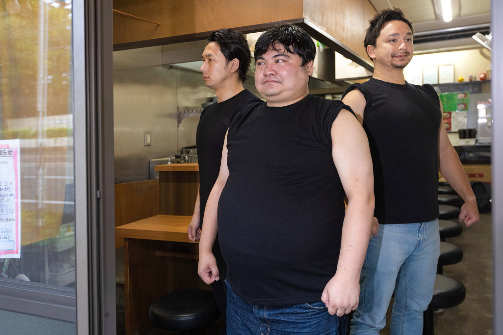 ラーメン店で黒いタンクトップの大柄な男性を中心に3人が並ぶ［モデル：段田隼人 大川竜弥 Max_Ezaki］
