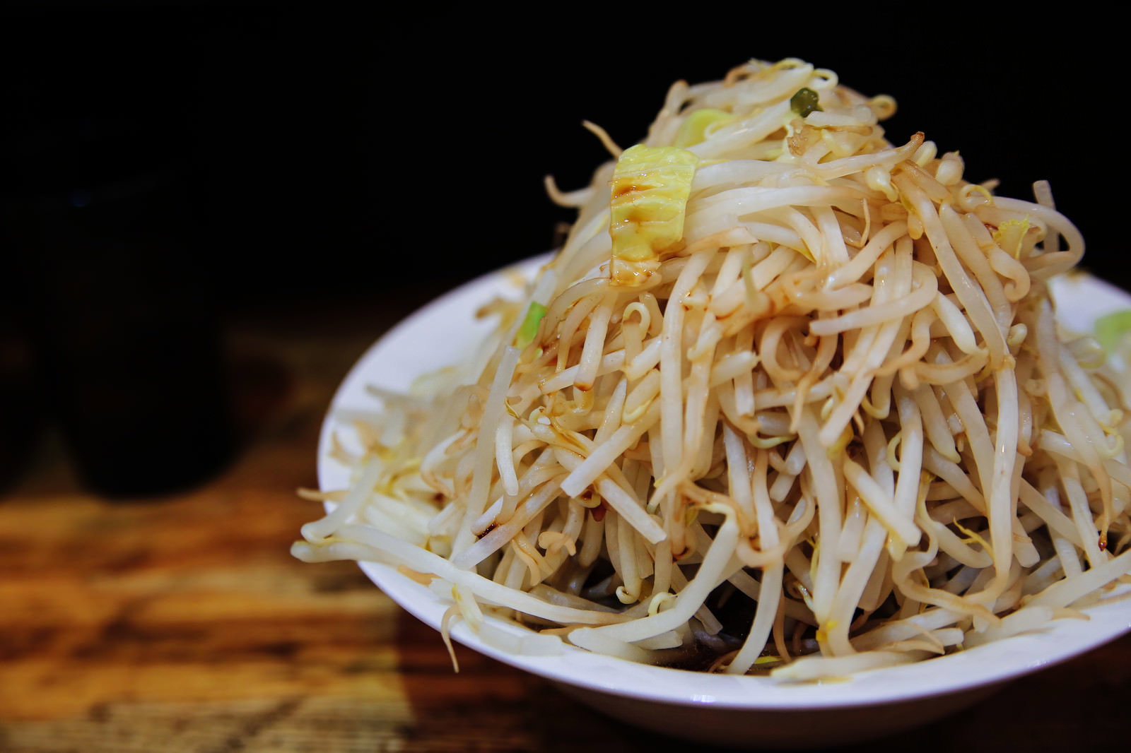 白い丼に山盛りのもやしが載ったラーメン