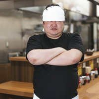 つけめん屋の店主が厨房で腕組みしてドヤ顔の写真