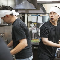 先輩の技を見て学ぼうとする新人アルバイトの写真