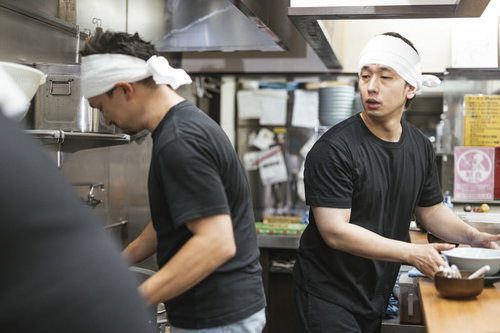 先輩の技を見て学ぼうとする新人アルバイト