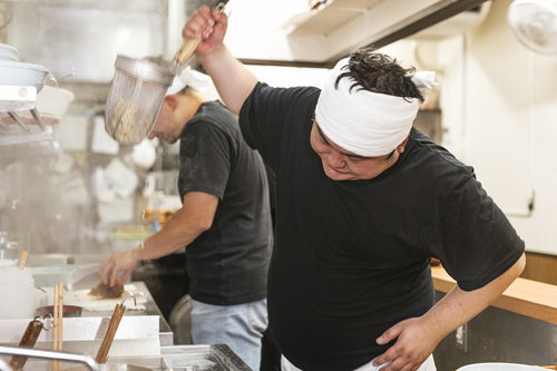 白いキャップのラーメン店主が厨房で披露する独特な湯切り