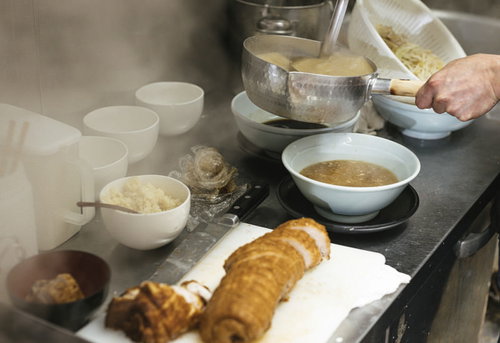 ラーメン厨房でスープとチャーシューを調理