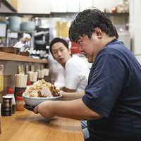 勢いでチョモランマ（ラーメン）を注文して後悔している男性客の写真