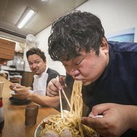 本能のままにラーメンの麺をバキュームする男性客の写真
