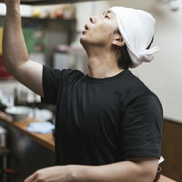 麺の硬さをタイマーでセットするラーメン屋の男性店員の写真