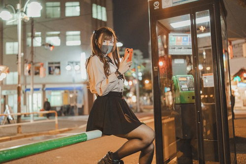 なに見てんのよ晒すわよ、夜の街角で電話ボックス前のマスク美女