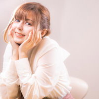 頬杖をついて微笑む女性のポートレートの写真