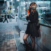 終電を逃したアメリカ人ハーフ女性、駅前でキャリーケースを持つの写真