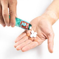 手のひらに出したラムネのお菓子は子ども向けの駄菓子の写真