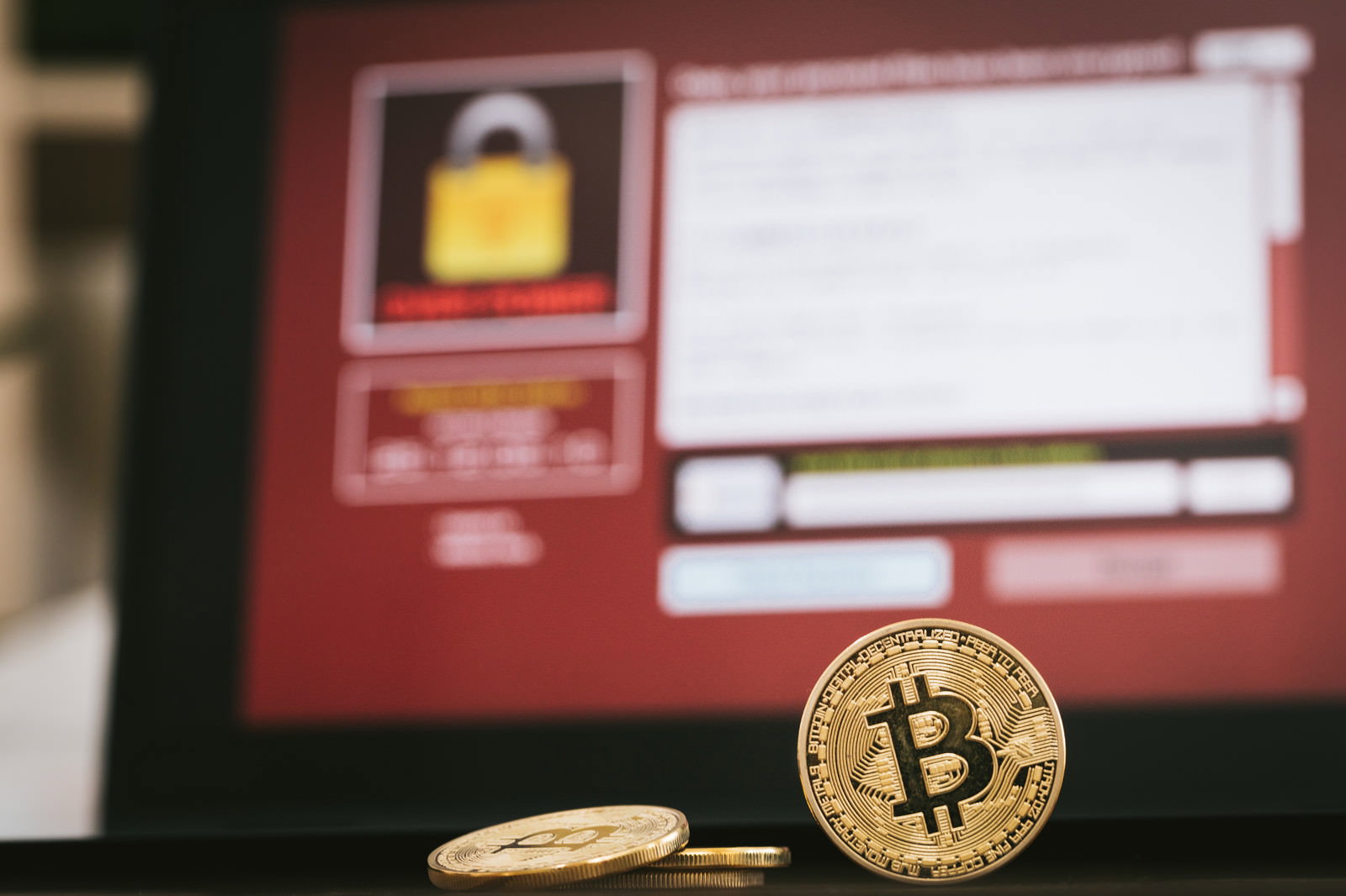 ランサムウェア画面の前に置かれたビットコインコイン