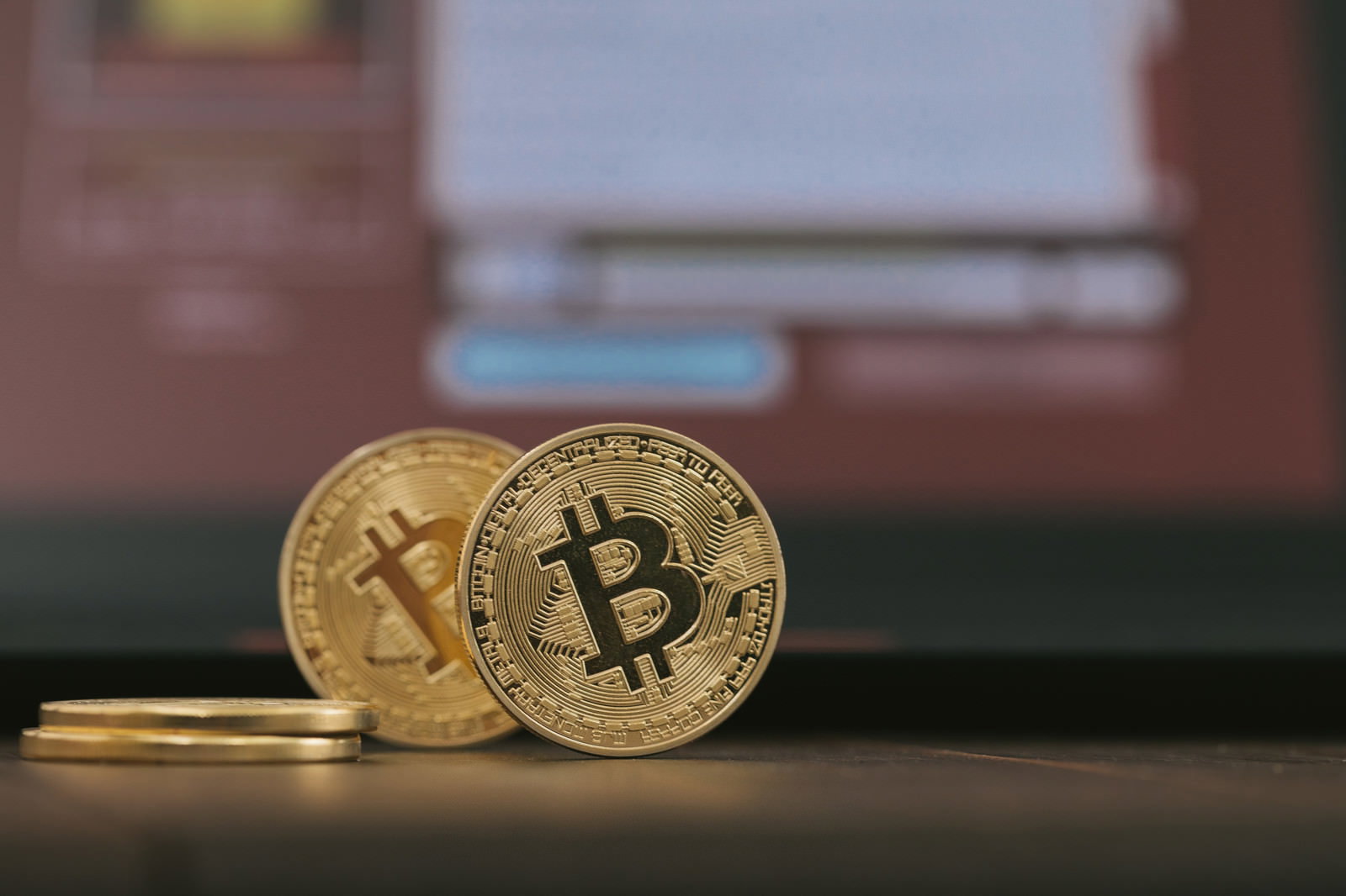 金色のビットコインコインとぼけたモニター