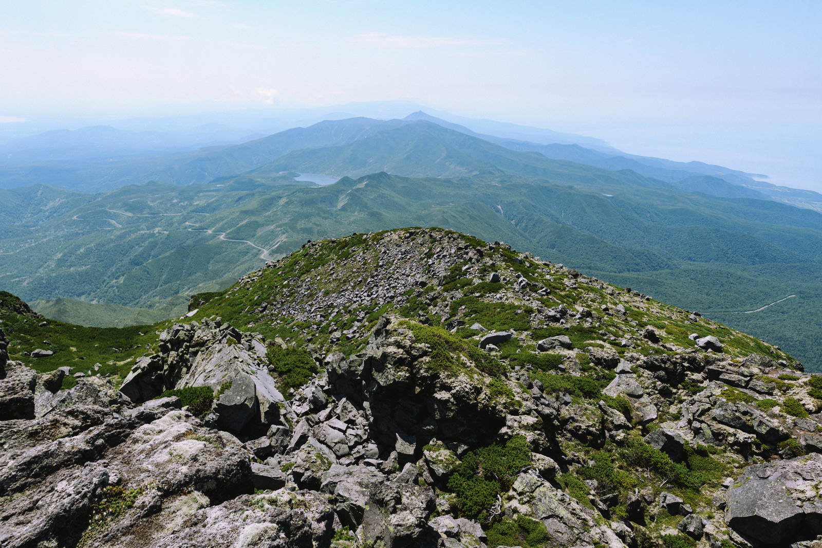 羅臼岳山頂の岩場から羅臼湖方面の山々と湖を望む風景