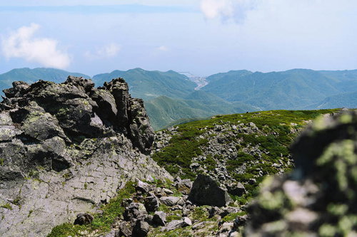 羅臼岳山頂から見下ろす岩場と羅臼の街並み