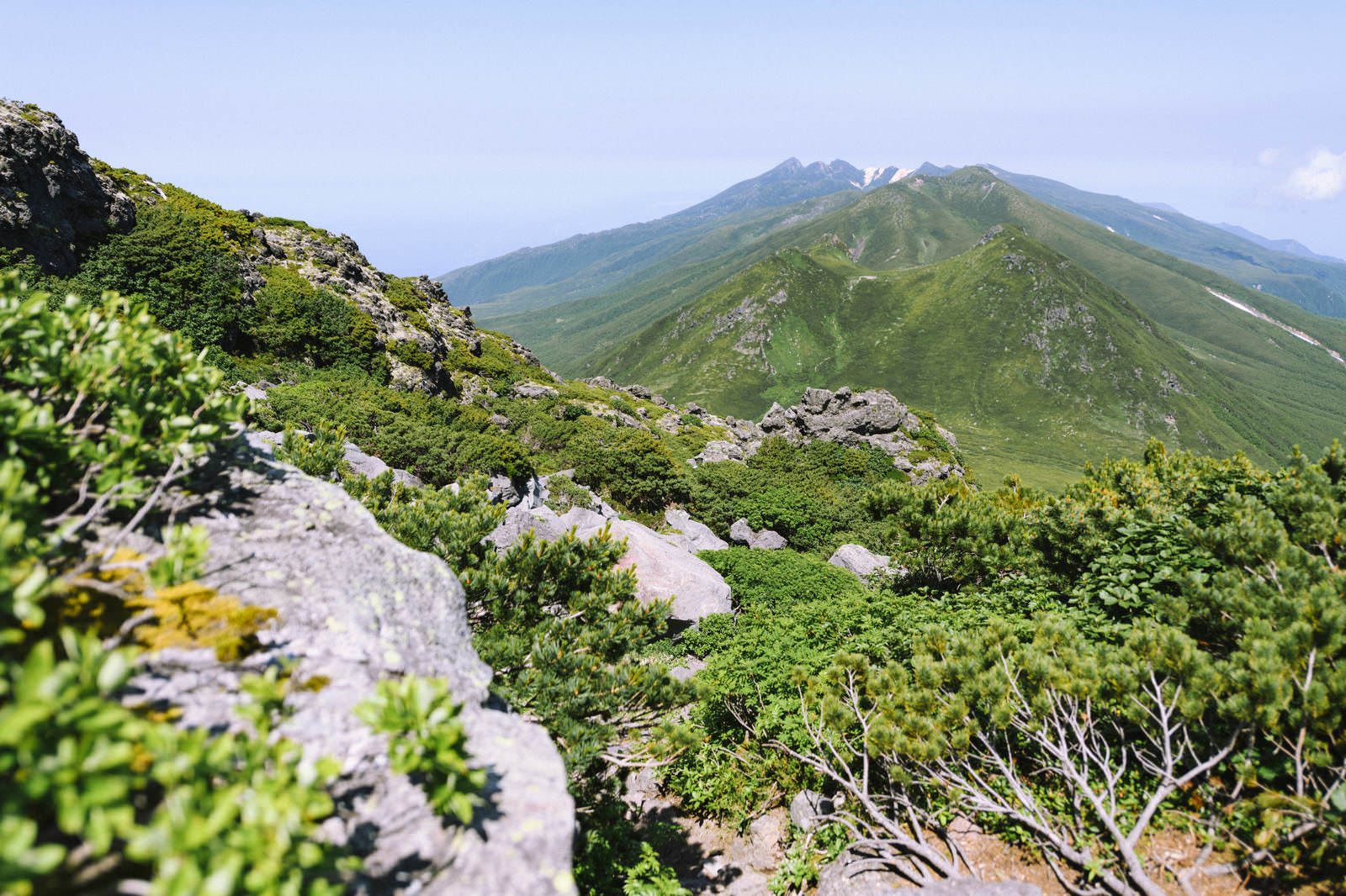 羅臼岳山頂直下の岩場から硫黄岳方面の山々を望む山岳風景