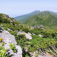 羅臼岳山頂直下の岩場から見る硫黄岳方面の山々の写真