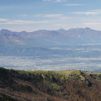 四阿山山頂から見渡す北信五岳と麓の街並みの広大な景観の写真