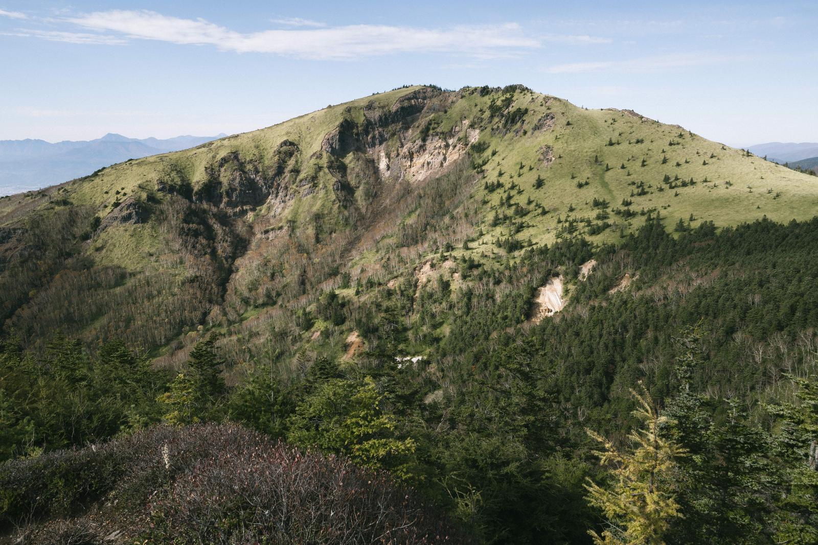四阿山登山道から撮影した、岩肌が露出した根子岳の断崖と森林