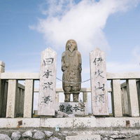 伊吹山山頂でヤマトタケル像を見守る石碑と祠の写真