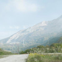 石灰採掘が進む伊吹山の裾野と露出した白い山肌の写真