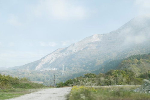 石灰採掘が進む伊吹山の裾野と露出した白い山肌