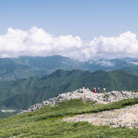 日本百名山・金峰山の稜線で眺望を楽しむ登山者たちの写真